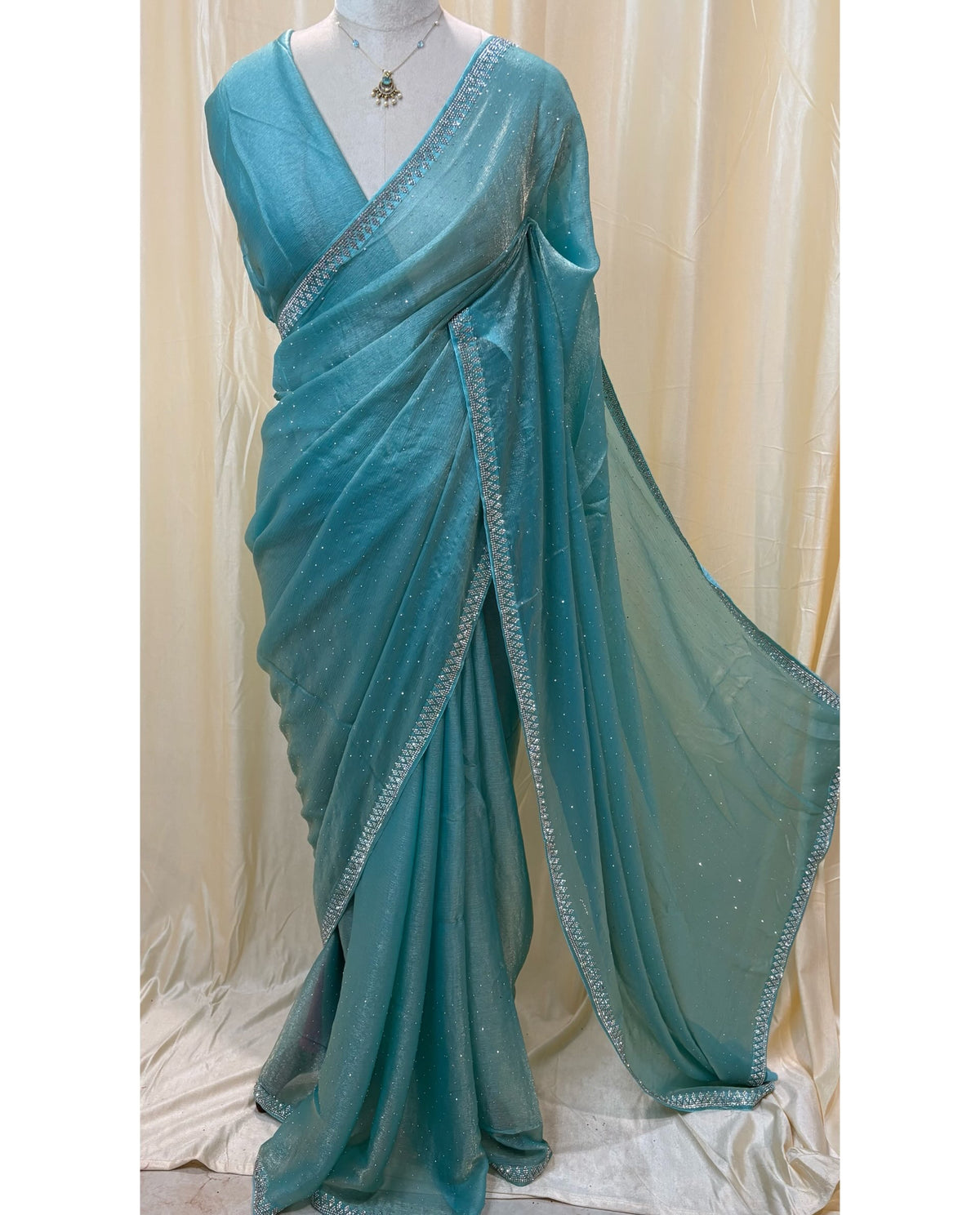 Sky blue georgette saree with white stones .