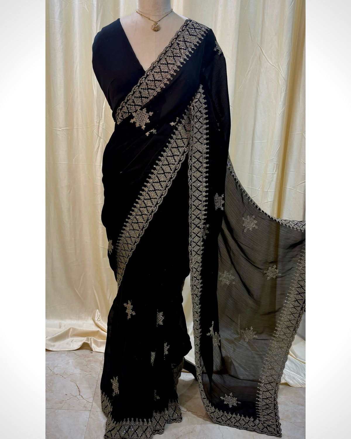 Black georgette saree with golden white embroidery.