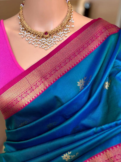 Peacock blue art silk saree comes with pink golden zari weave border.