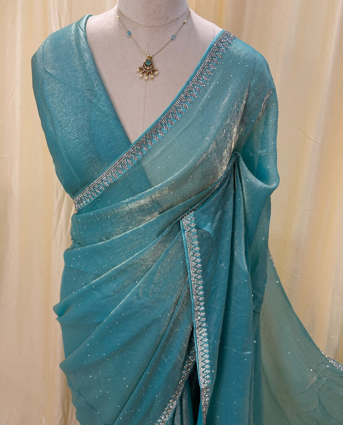 Sky blue georgette saree with white stones .