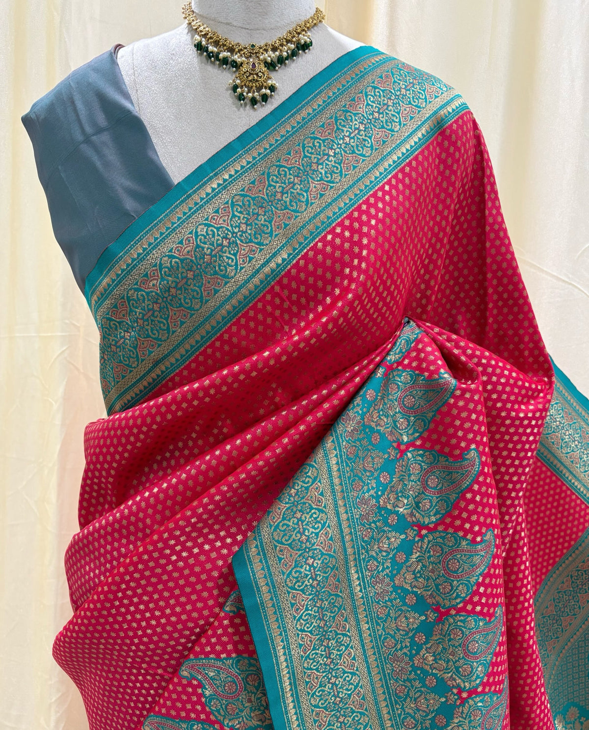Rani pink brocade silk saree with teal blue border.