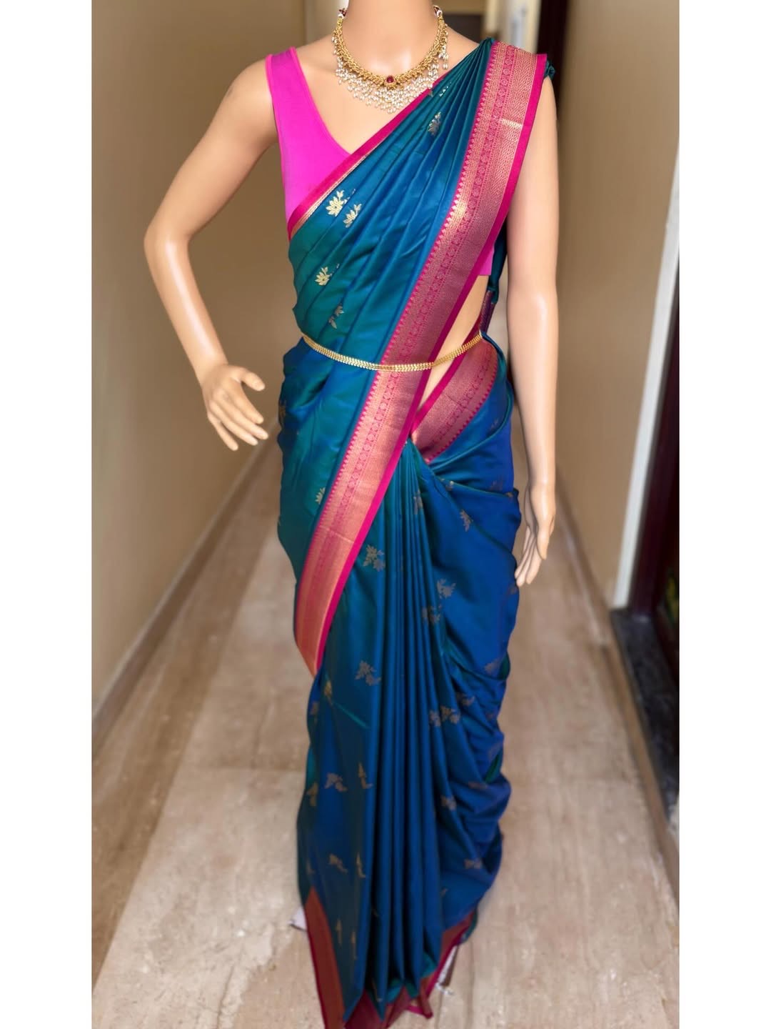 Peacock blue art silk saree comes with pink golden zari weave border.