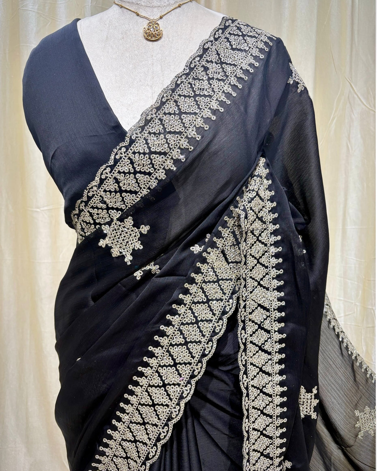 Black georgette saree with golden white embroidery.