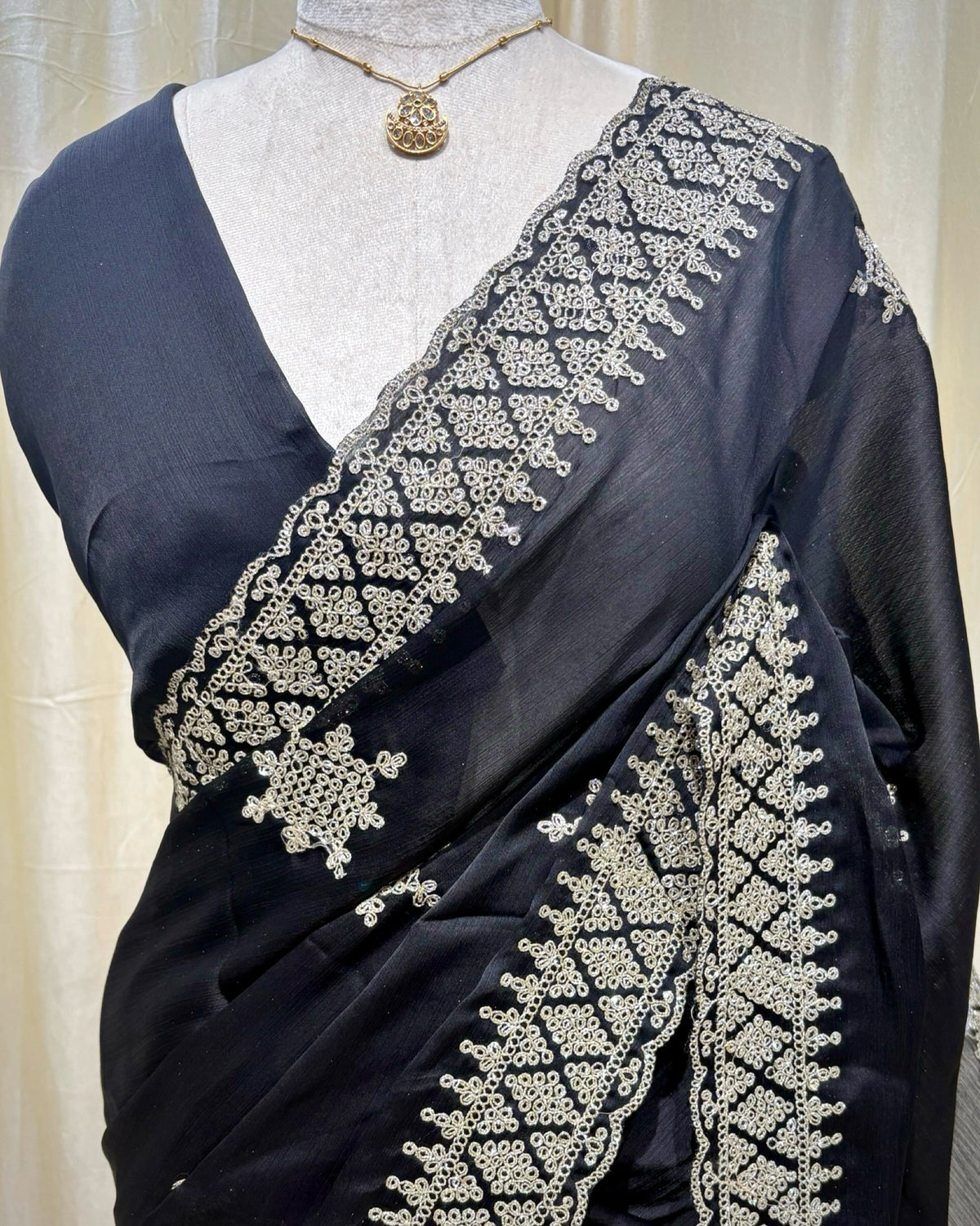 Black georgette saree with golden white embroidery.