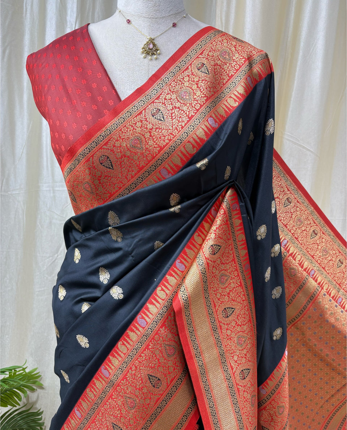 Black art silk saree with red border.