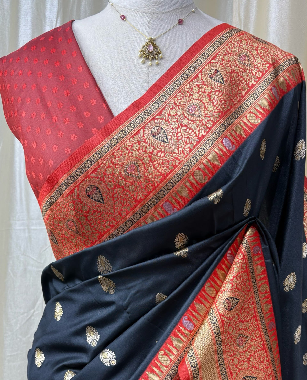 Black art silk saree with red border.