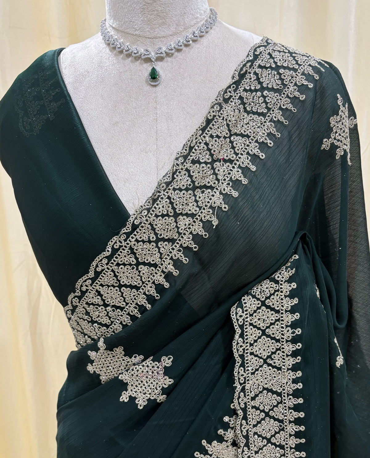 Bottle green georgette saree with golden white embroidery.