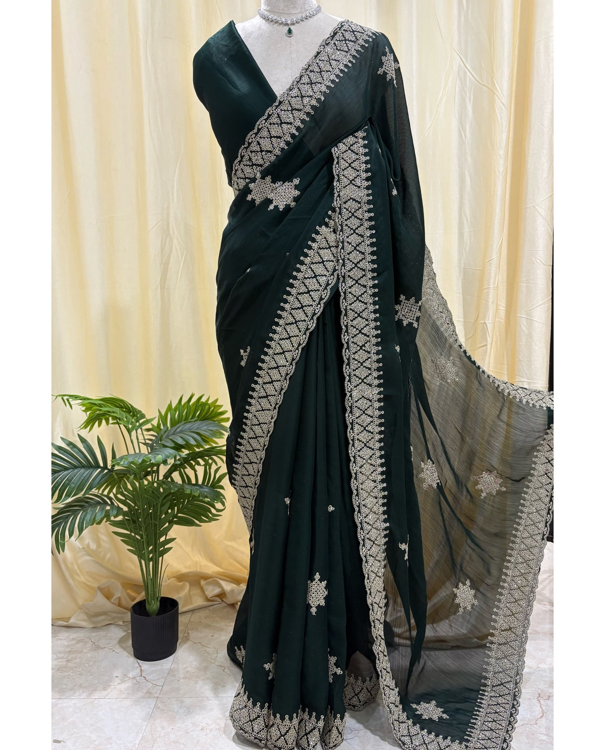 Bottle green georgette saree with golden white embroidery.