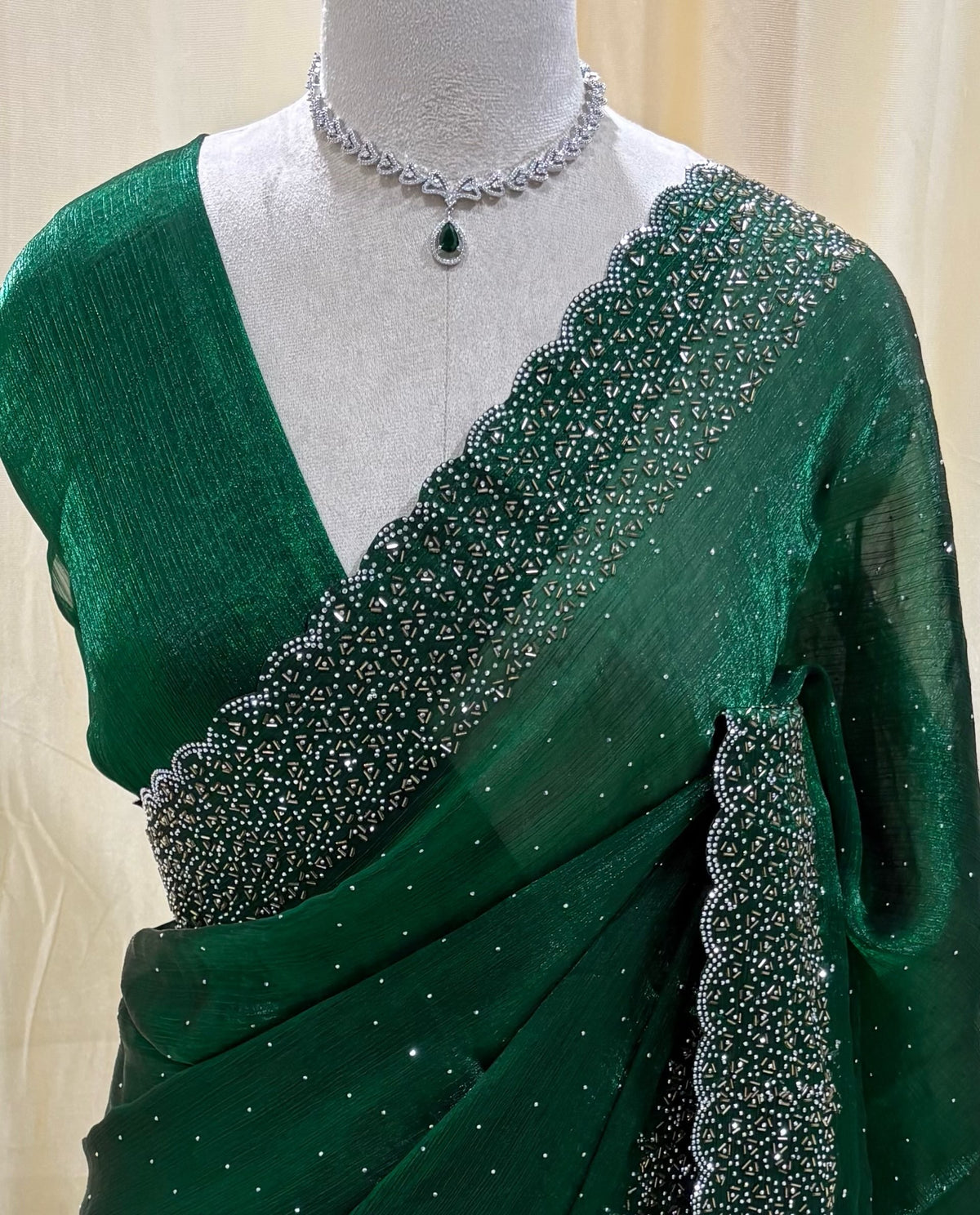 Bottle green georgette saree with white stones.