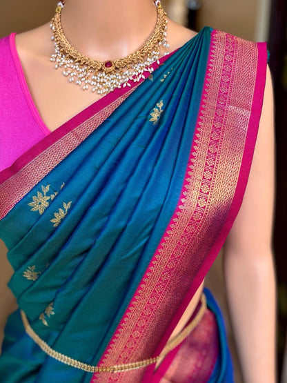 Peacock blue art silk saree comes with pink golden zari weave border.