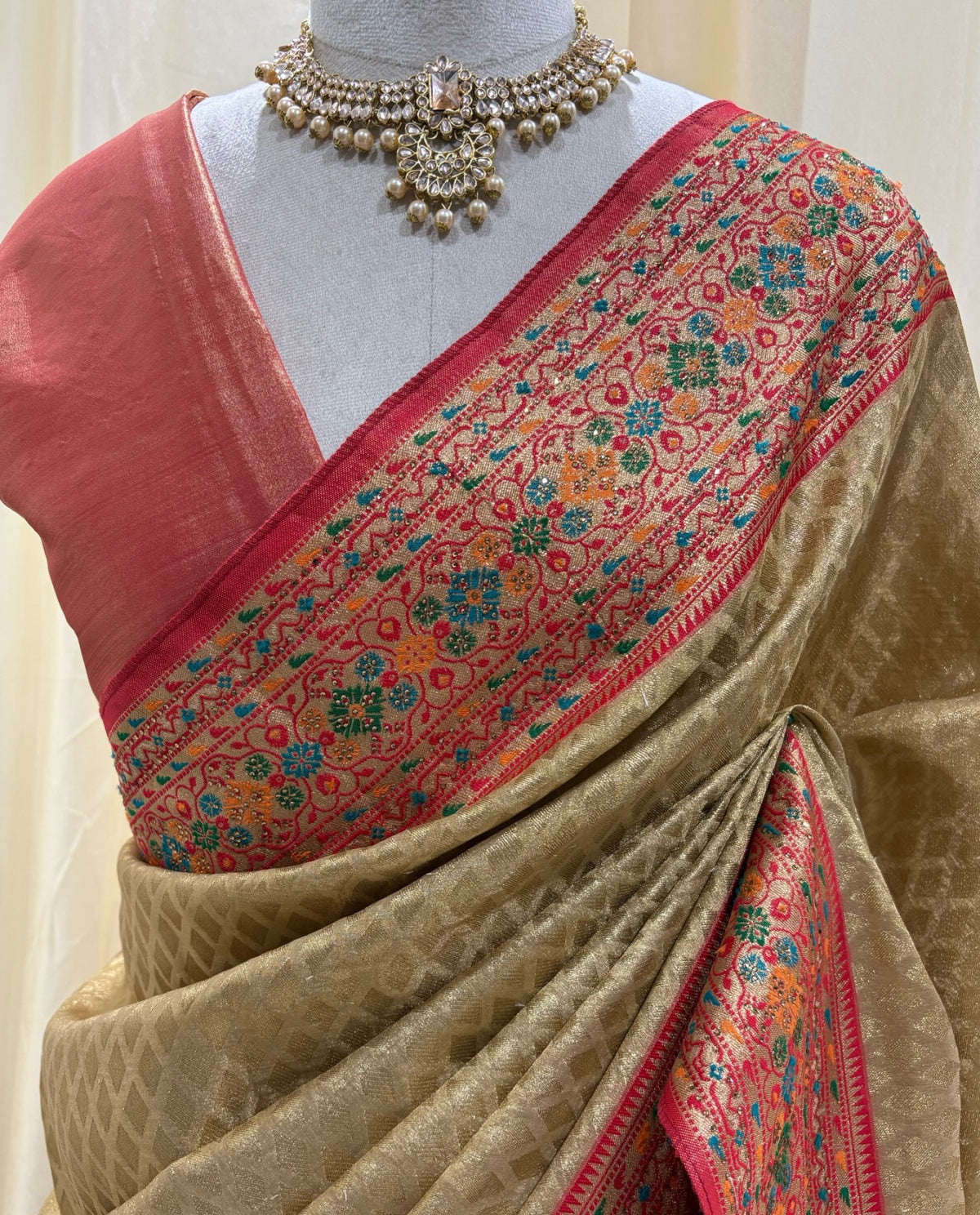 Golden diamond tissue silk saree with red border.