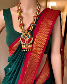 Bottle green cotton silk full butta saree with red border.