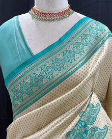 Ivory white brocade silk saree with teal blue border