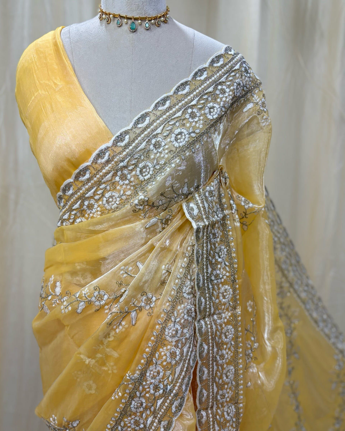 Lemon yellow soft organza saree with white embroidery all over saree.
