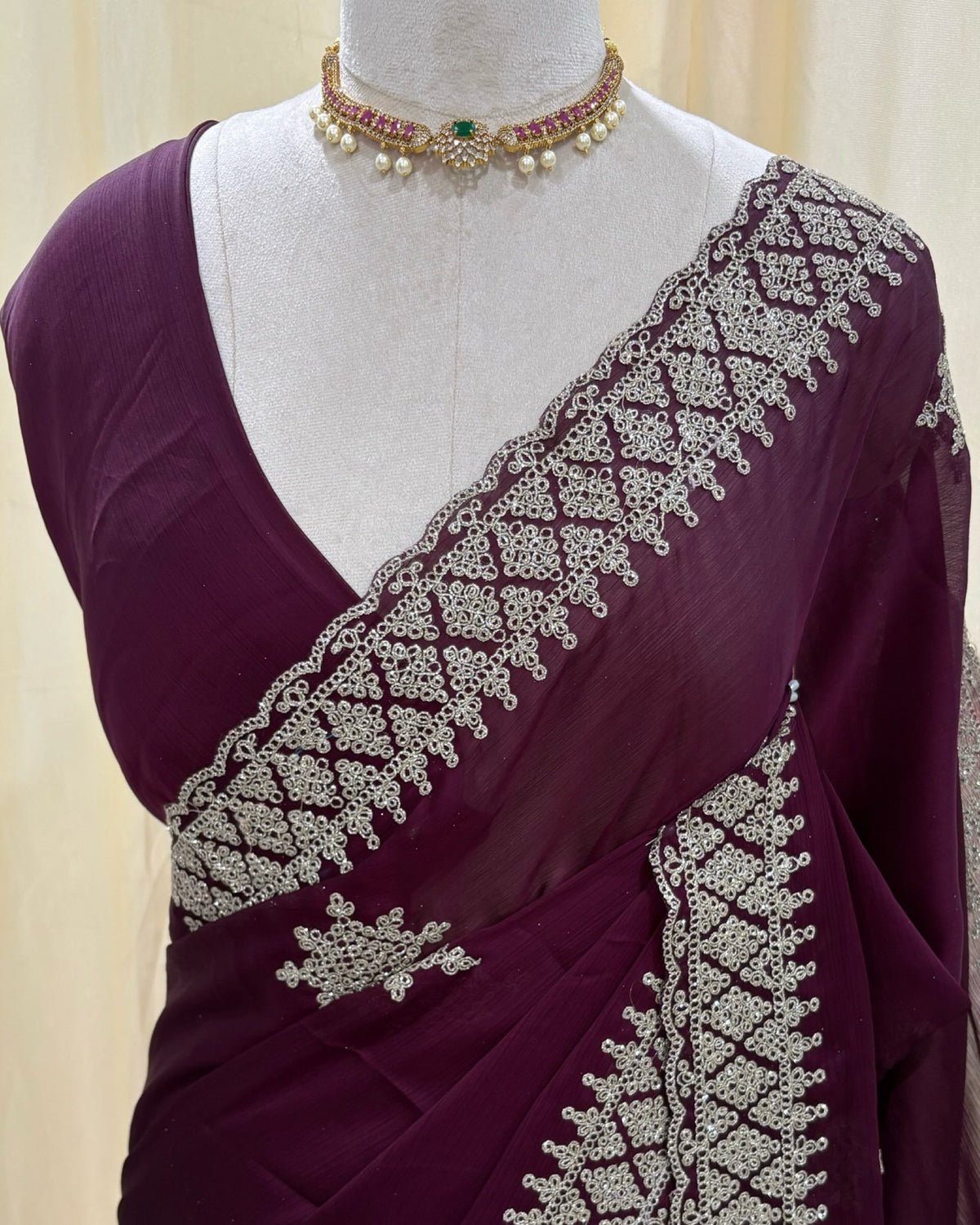 Magenta georgette saree with golden white embroidery.