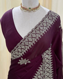 Magenta georgette saree with golden white embroidery.