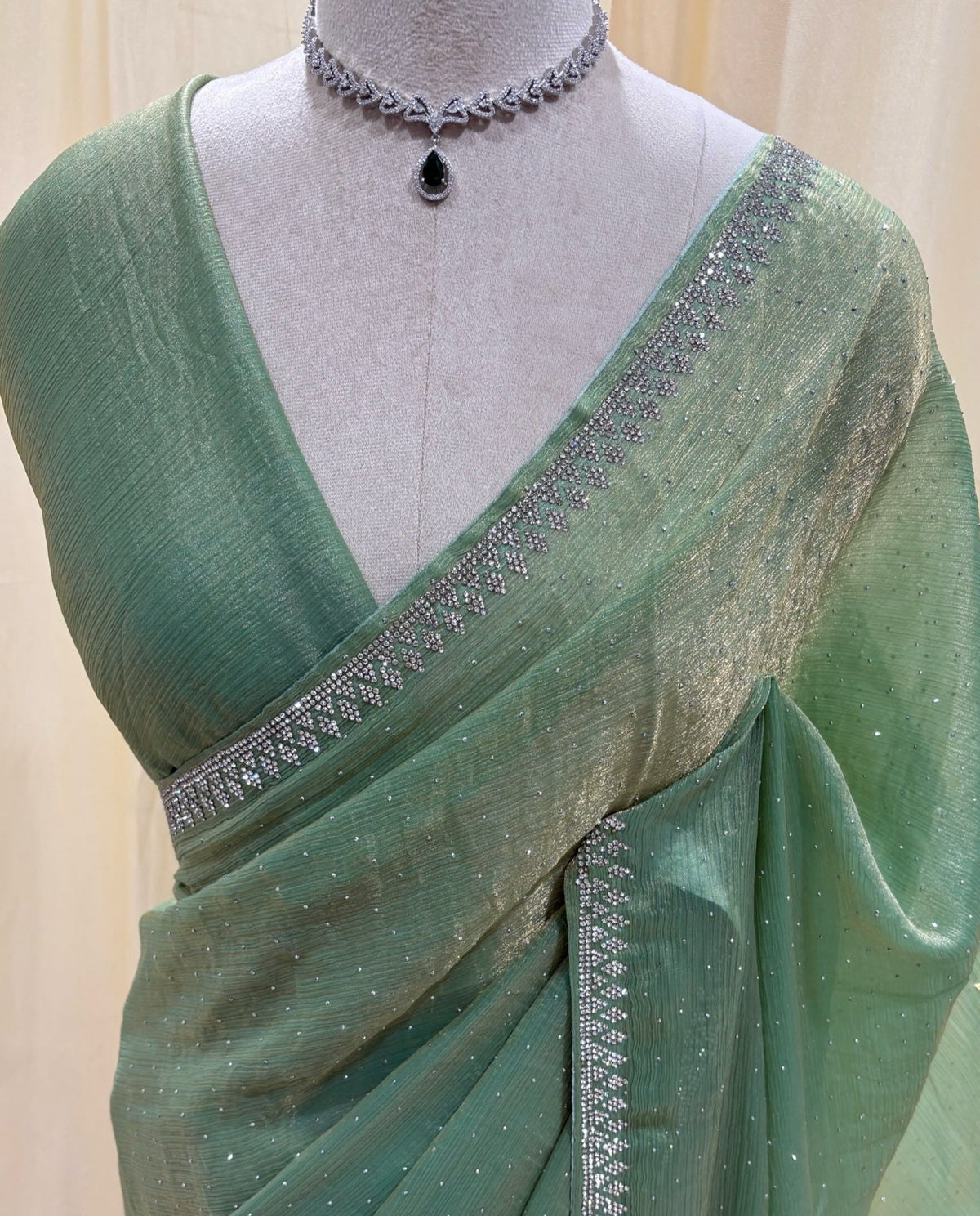 Pastel green georgette sarees with white stones.
