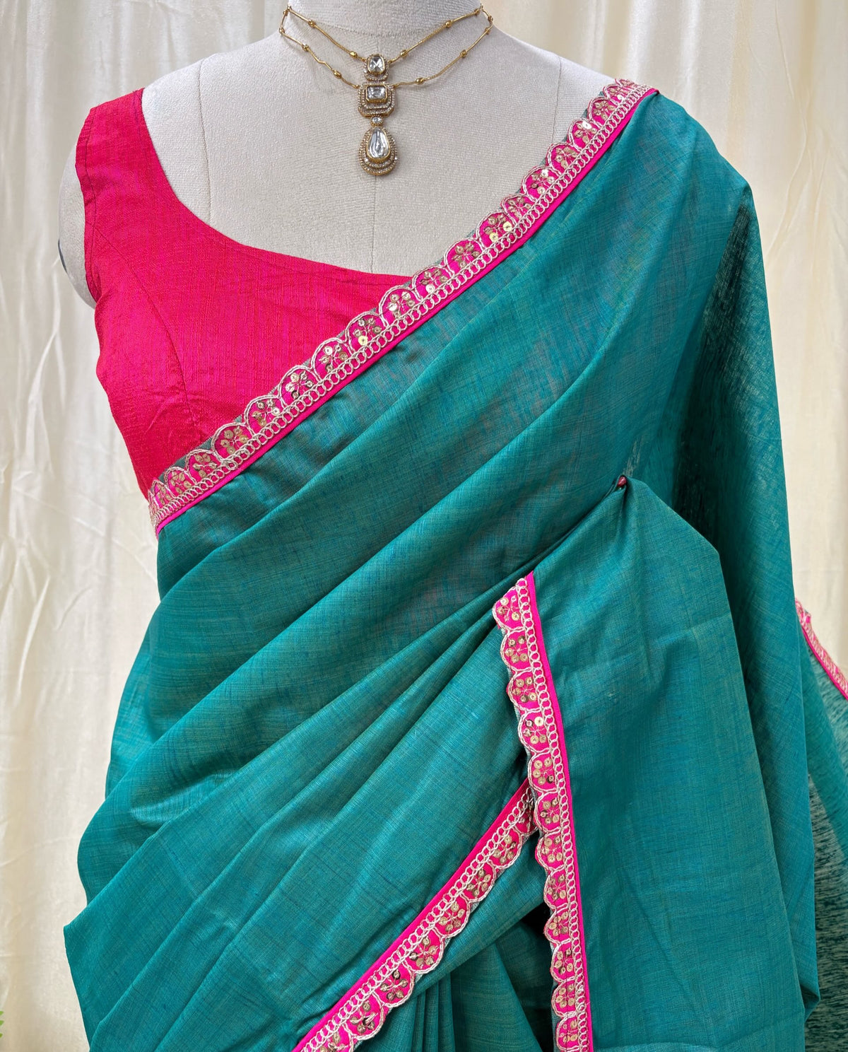 Peacock green dupion silk saree with pink border.
