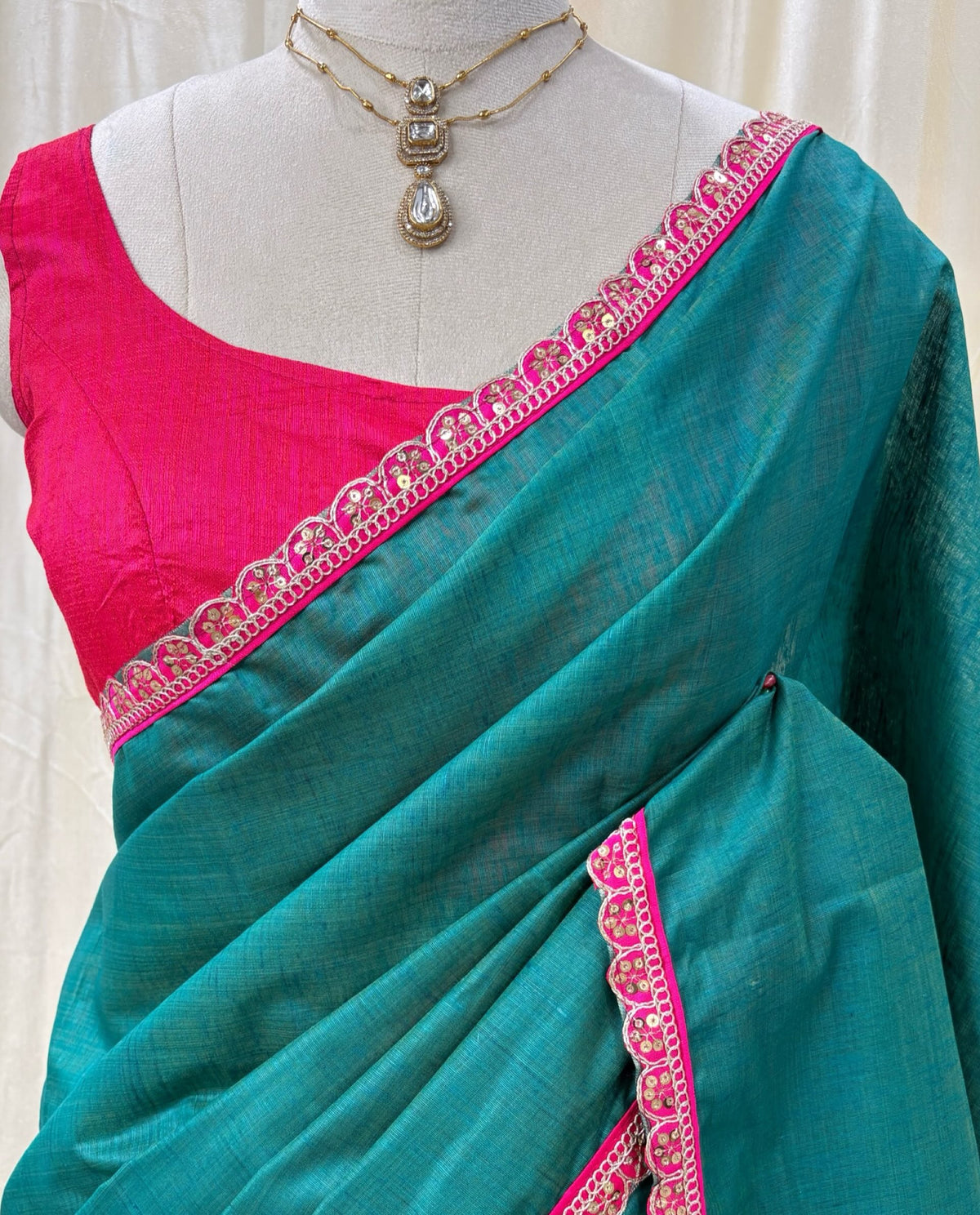 Peacock green dupion silk saree with pink border.