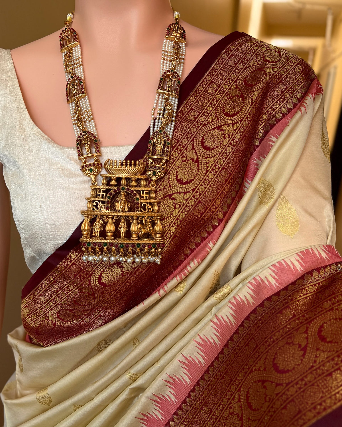 Ivory white art silk saree with reddish maroon temple border.