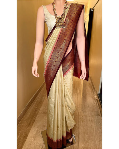 Ivory white art silk saree with reddish maroon temple border.