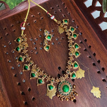 Antique gold necklace with rich green enamel work.