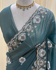 Teal blue georgette saree with white embroidery.