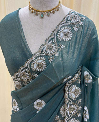 Teal blue georgette saree with white embroidery.