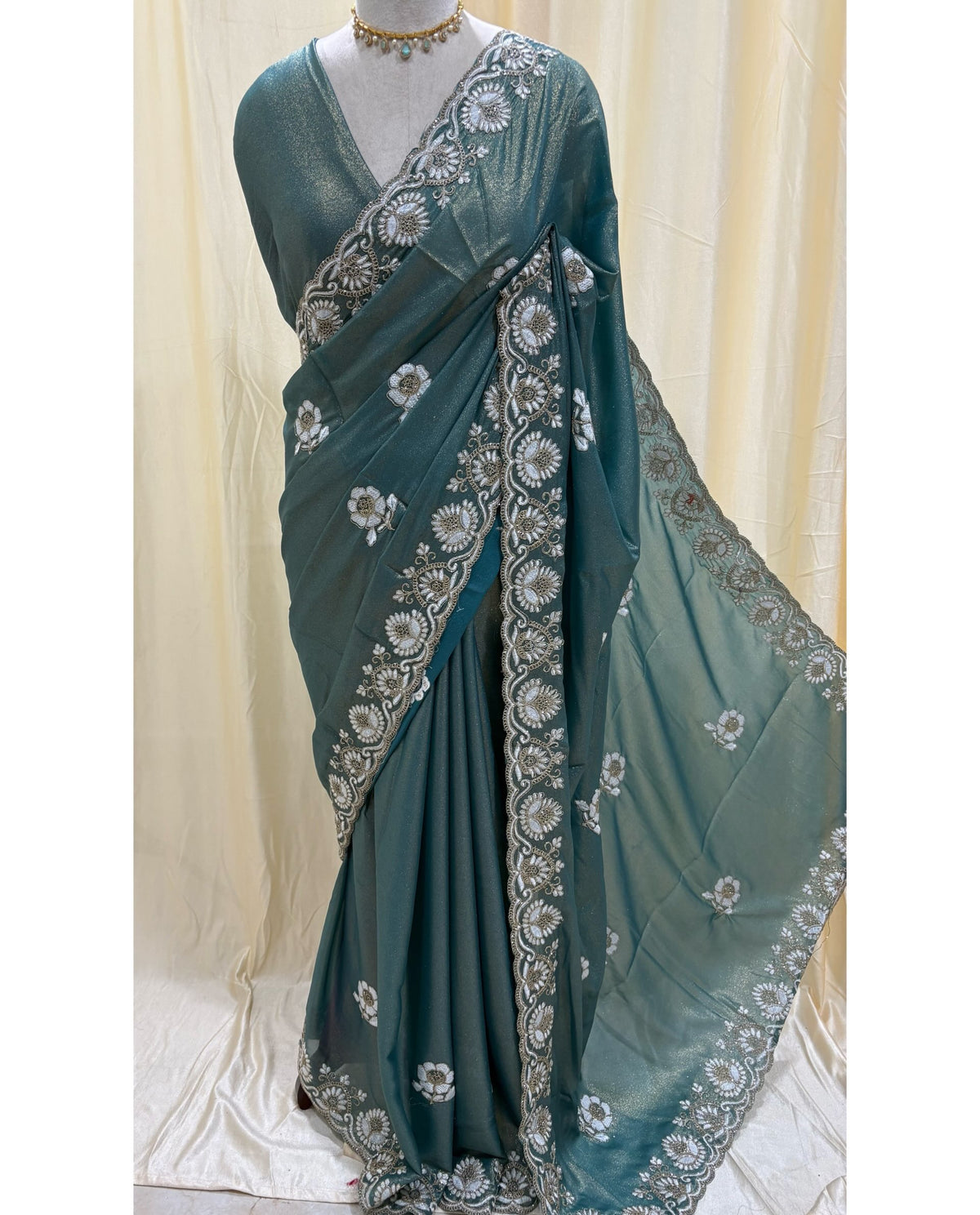 Teal blue georgette saree with white embroidery.