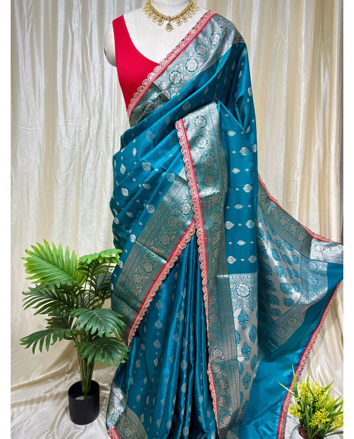 Teal blue satin ailk saree with red lace.