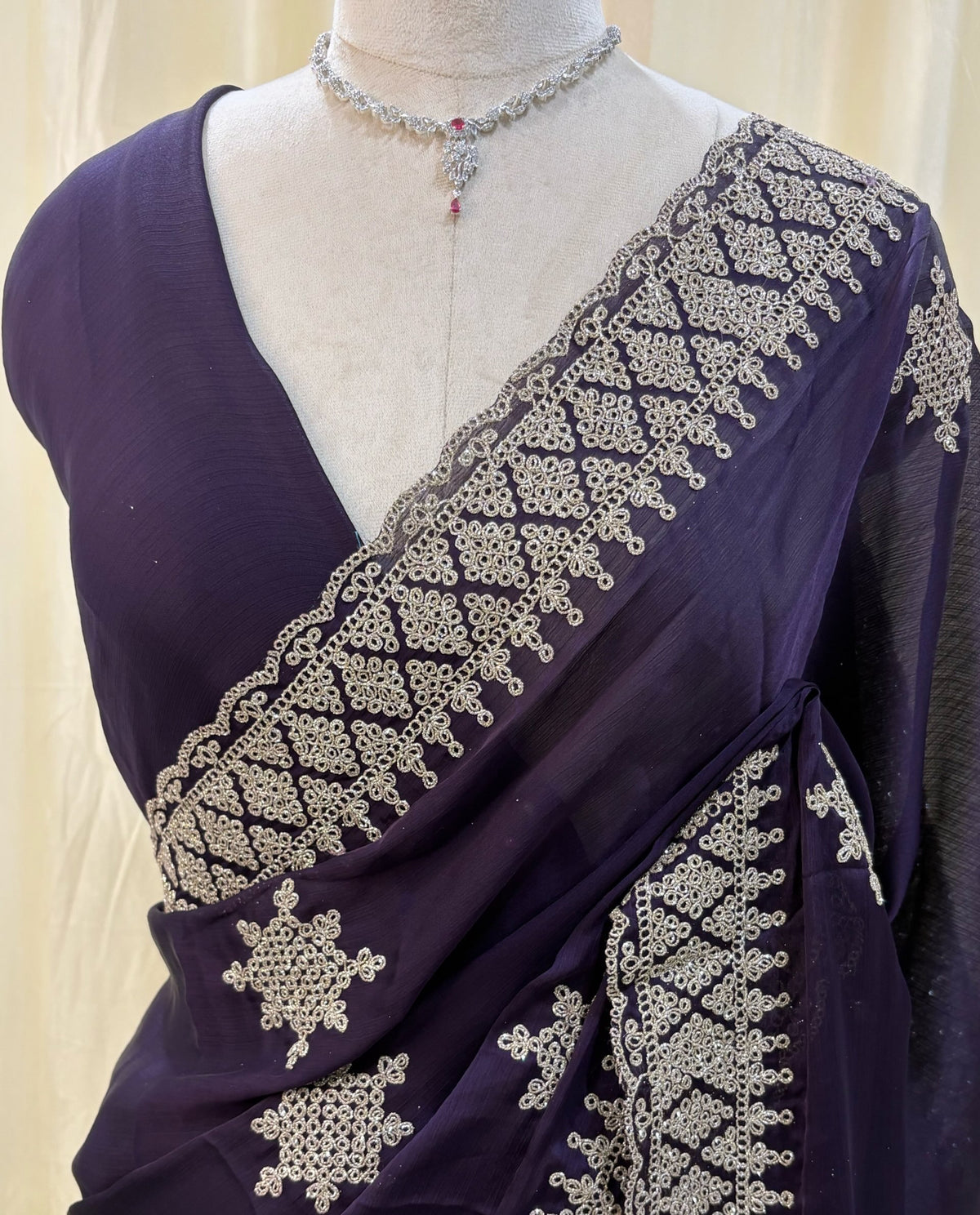 Violet georgette saree with golden white embroidery.