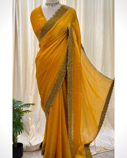 Yellow georgette saree with white stones.